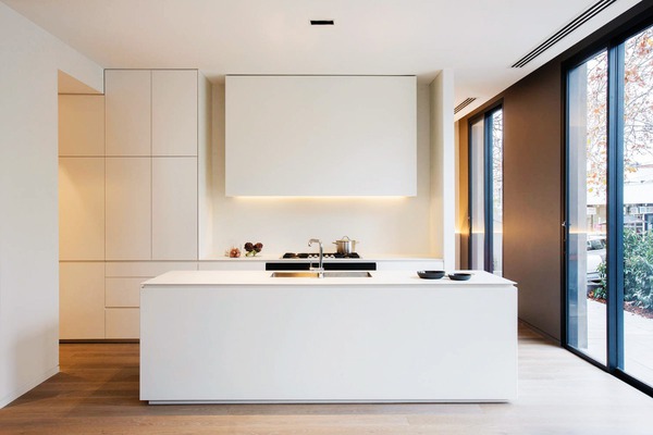 Không gian phòng bếp tối giản với tủ bếp chữ I và đảo bếp đều có màu trắng
