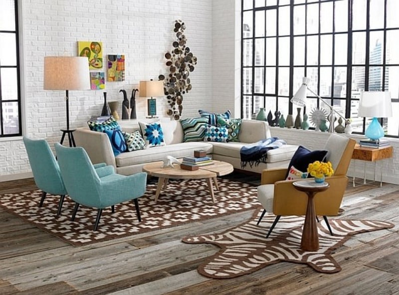 Không gian phòng khách với trung tâm là bộ sofa được thiết kế thanh thoát, các phụ kiện trang trí như gối tựa, tranh treo tường, thảm trải sàn xuất hiện với màu sắc và hoa văn rất đặc trưng