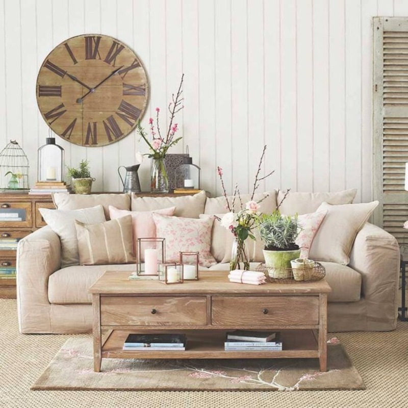 Phòng khách với bộ sofa làm điểm nhấn nổi bật, kết hợp với các phụ kiện trang trí mang đậm hơi thở đồng quê như chậu cây, bình hoa, đồng hồ